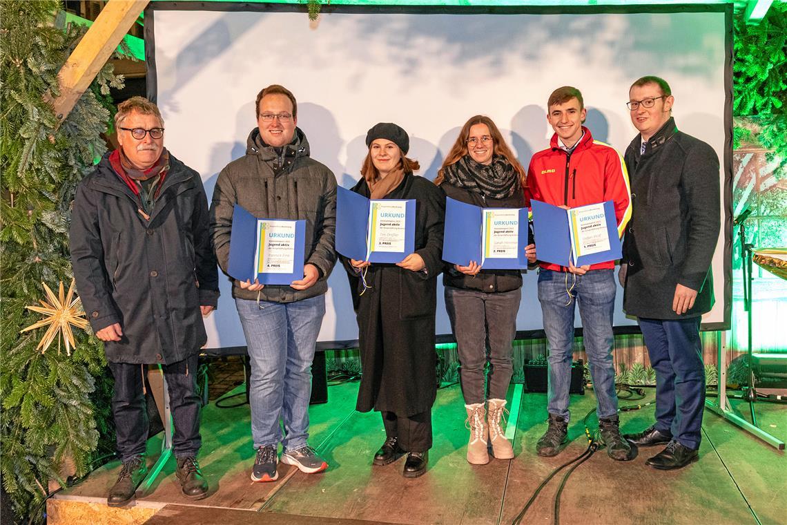 Klaus Böhle (links) und Oberbürgermeister Maximilian Friedrich (rechts) überreichen Yannick Fink, Marlene Heitkämper (stellvertretend für Tim Dreßler), Sarah Herrmann und Stefan Wolf (von links) die Urkunden und Einkaufsgutscheine auf der Waldbühne im Stiftshof. Foto: Dietmar van der Linden