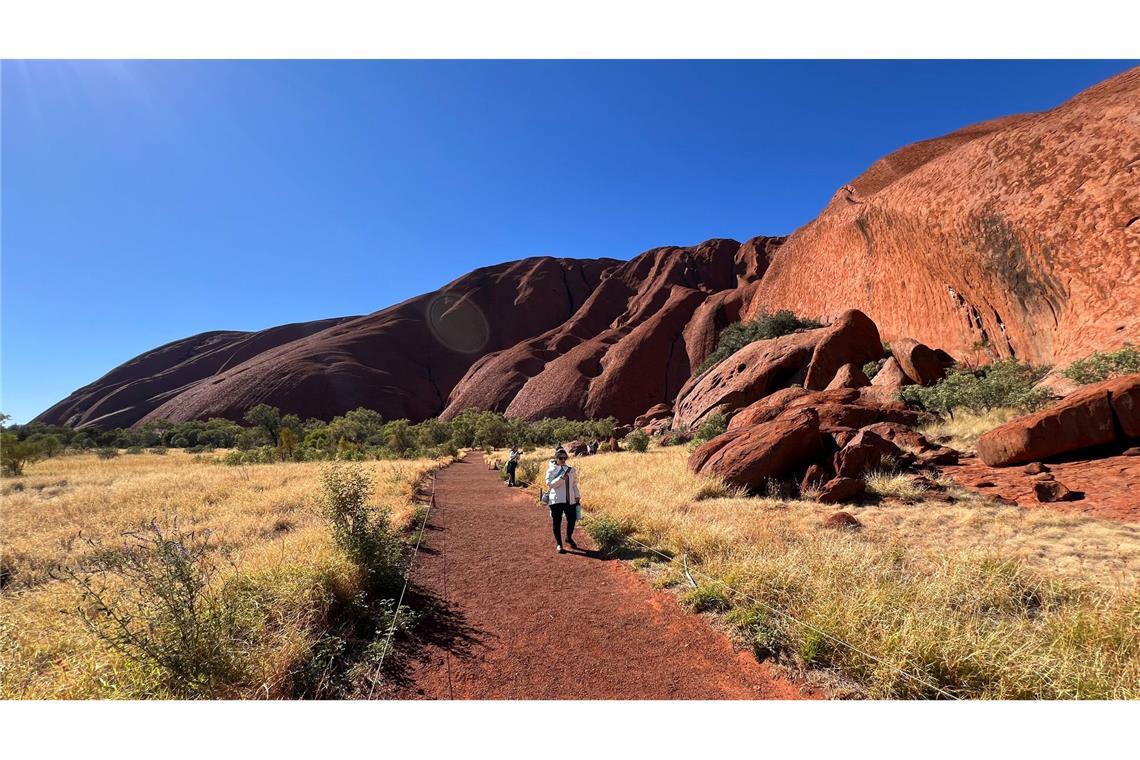 Klettern ist zwar verboten, aber Touristen können über Gehwege um den Uluru herumlaufen.