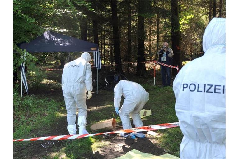 Kriminalbeamte untersuchen bei Heidenheim-Nietheim den Waldboden. Foto: Stefan Puchner/dpa/Archivbild