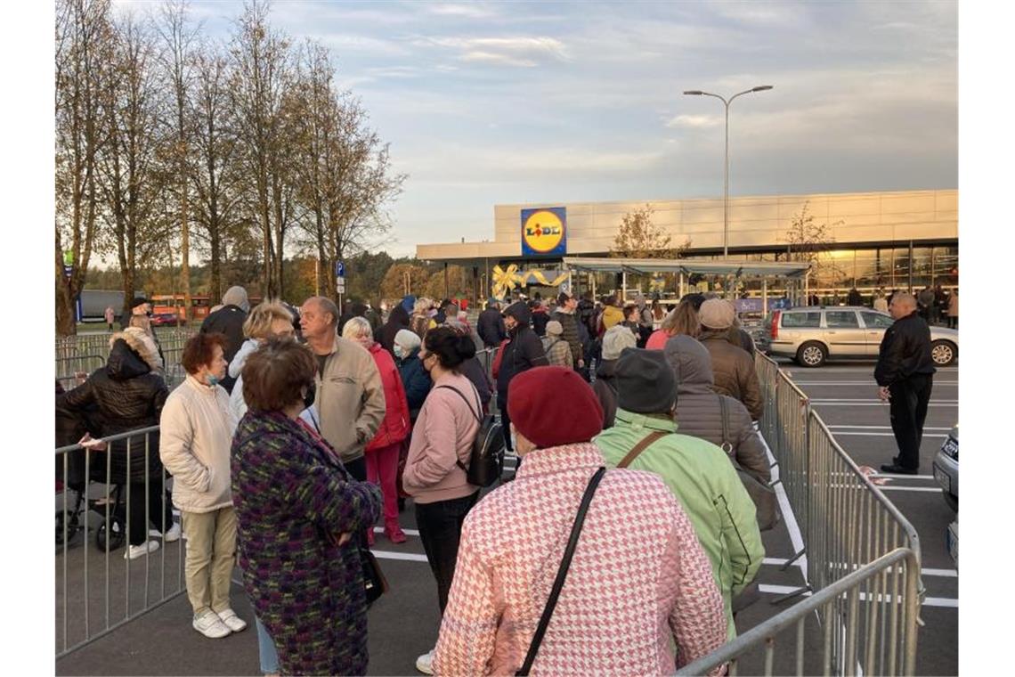 Kunden stehen nach der Eröffnung einer Lidl-Filiale in Riga Schlange. Foto: Alexander Welscher/dpa