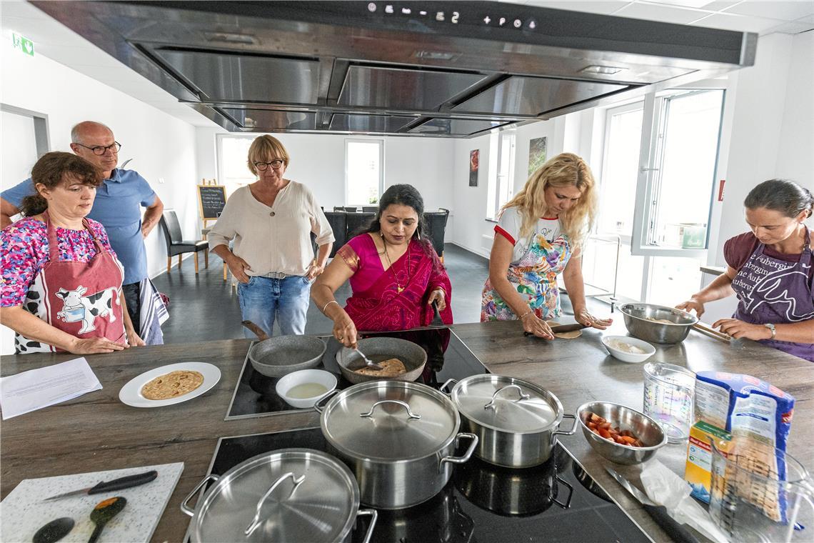 Kursleiterin Urvi Shah (Mitte) zeigt die Zubereitung von Paratha, gebratenen Fladenbroten. Foto: Dietmar van der Linden