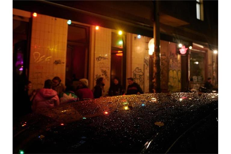 Kurz nach der Sperrstunde sind noch Gäste vor einer Bar in Neukölln. Foto: Annette Riedl/dpa