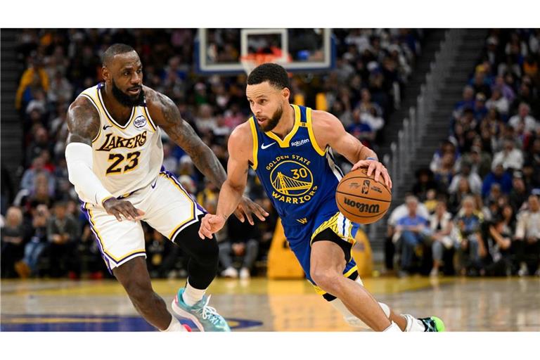 LeBron James (l) und die Los Angeles Lakers setzten sich bei den Golden State Warriors um Stephen Curry durch.