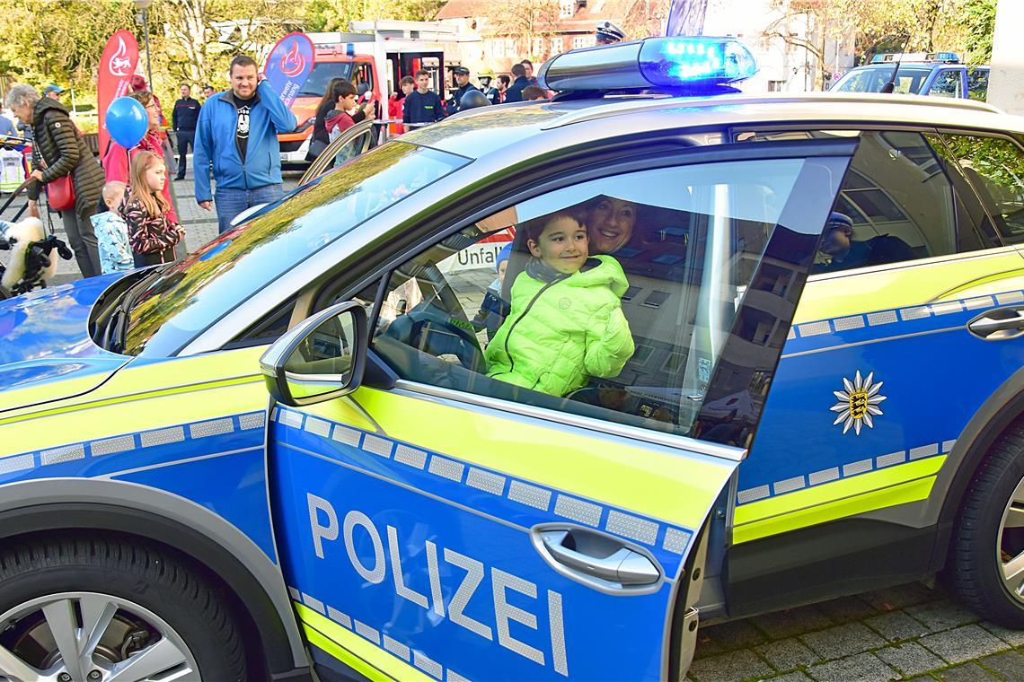 Leuchtende Kinderaugen. Die Kleinen dürfen in einem echten Polizeiauto mit Blaul...