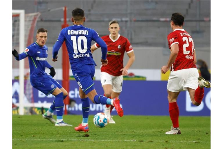 Leverkusens Kerem Demirbay (10, 2.v.l.) spielt den Ball zu Leverkusens Florian Wirtz (l), während Freiburgs Nico Schlotterbeck und Freiburgs Nicolas Höfler (r) versuchen, den Ball zu erreichen. Foto: Philipp von Ditfurth/dpa/Archivbild