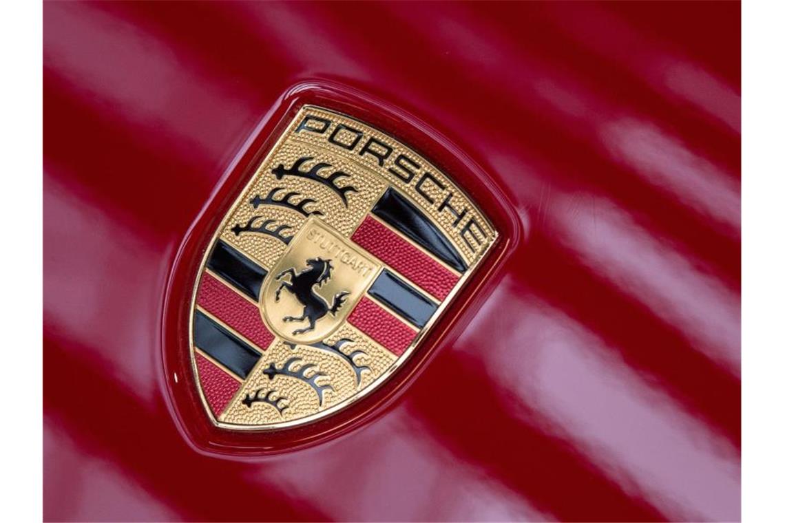 Licht reflektiert auf dem Logo des Sportwagenbauers Porsche. Foto: Sebastian Gollnow/dpa/Symbolbild