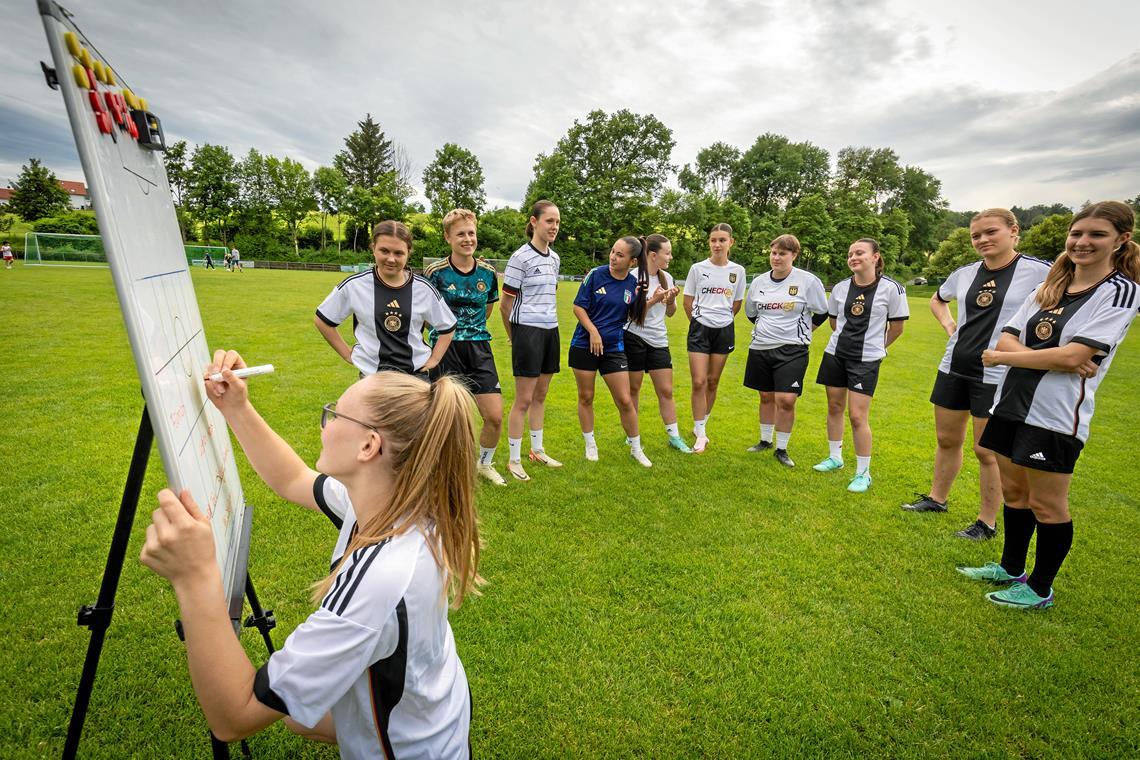 Lilli Übele schreibt die gemeinsam erarbeitete deutsche Aufstellung auf die Taktiktafel. Foto: Alexander Becher