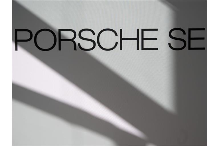 Logo und Schriftzug der Porsche SE sind an einer Stellwand zu sehen. Foto: Marijan Murat/dpa/Symbolbild