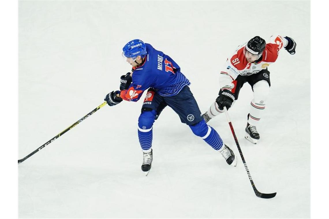 Mannheims Ilari Melart (l) und Frölundas Mats Rosseli-Olsen kämpfen um den Puck. Foto: Uwe Anspach/dpa