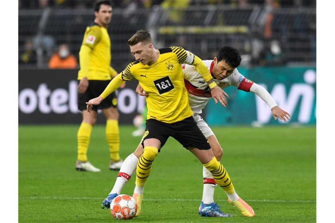 Marco Reus (l) von Borussia Dortmund und Wataru Endō vom VfB Stuttgart kämpfen um den Ball. Foto: Bernd Thissen/dpa