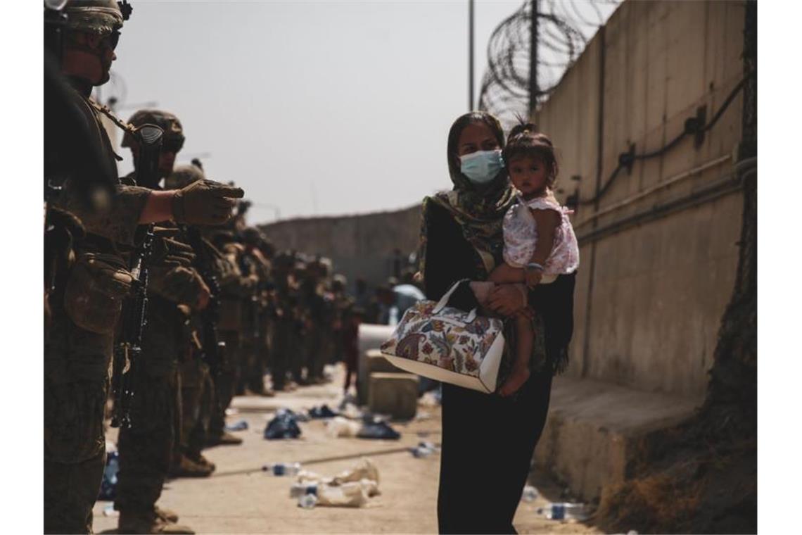 Verzweiflung in Kabul - Berichte über Hinrichtungen Marinesoldaten führen eine Frau, die ein Kind auf dem Arm trägt, während einer Evakuierung am Flughafen in Kabul. Foto: U.S. Marines/ZUMA Press Wire Service/dpa