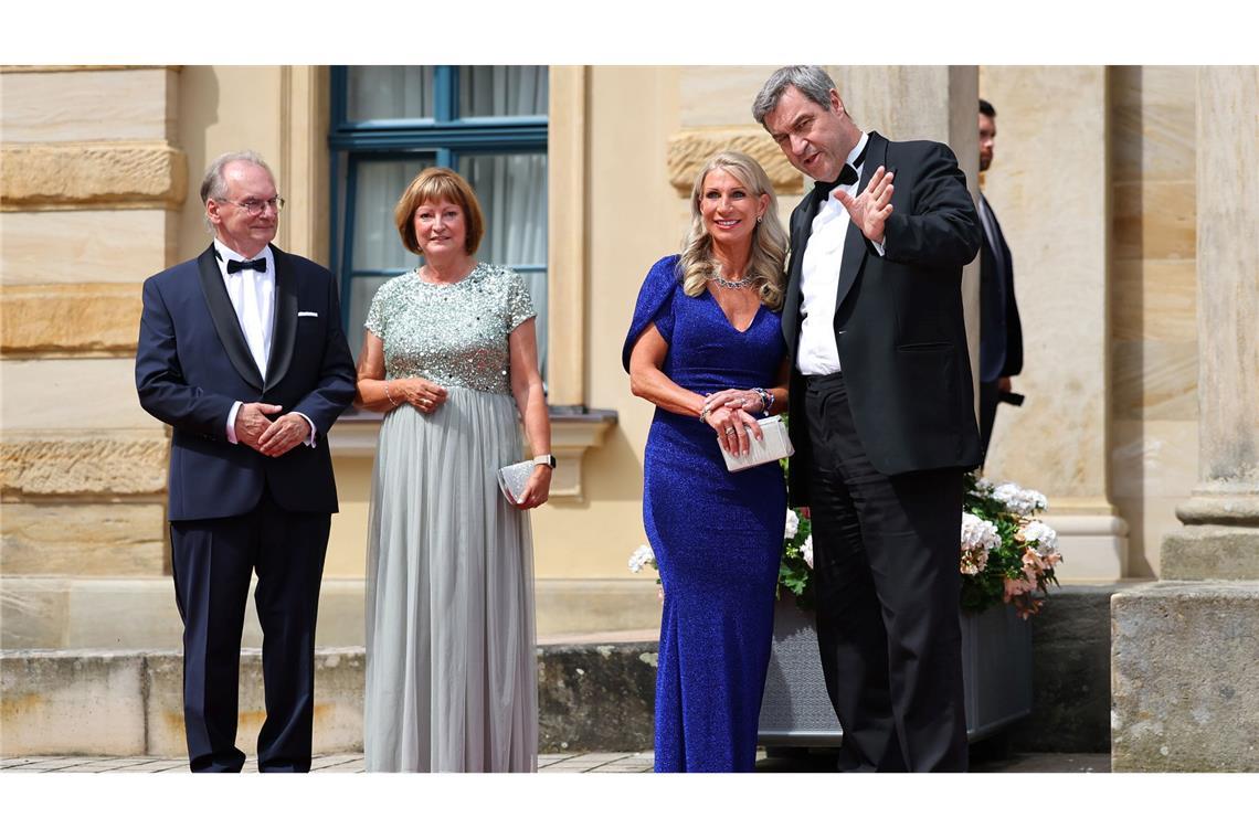 Markus Söder, Ministerpräsident von Bayern, und seine Frau Karin Baumüller-Söder, stehen zusammen mit Reiner Haseloff (CDU), Ministerpräsident von Sachsen-Anhalt, und seiner Frau Gabriele vor dem Bayreuther Festspielhaus.