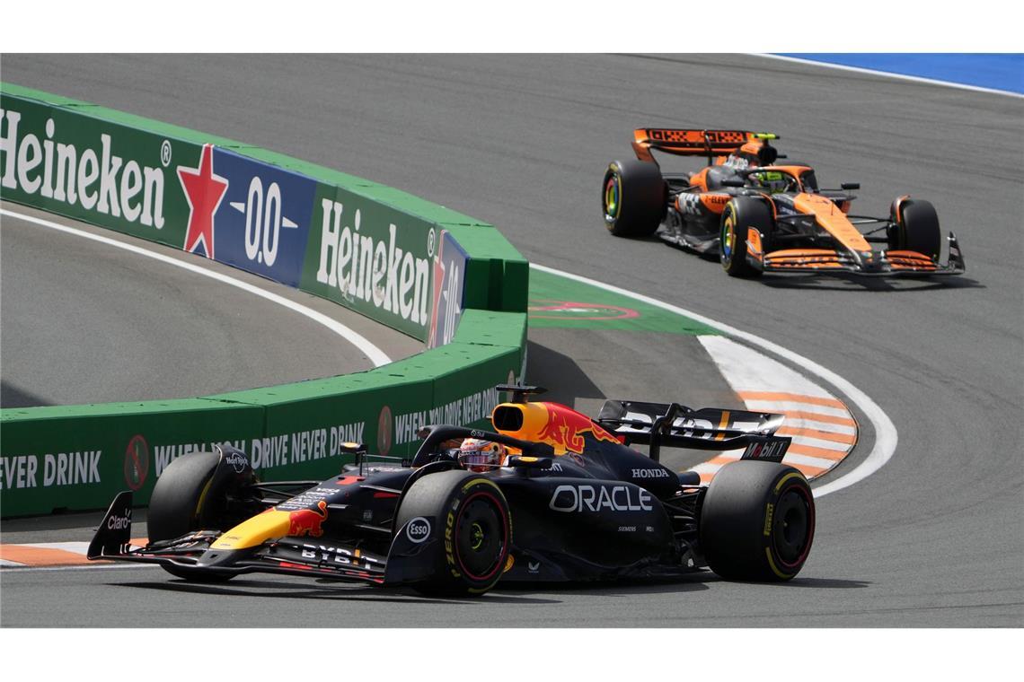 Max Verstappen (l) überholt Lando Norris am Start.