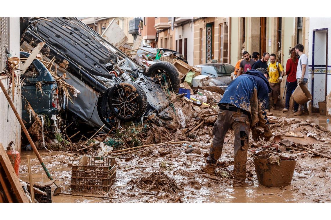 Menschen beseitigen in Paiportadie durch das Unwetter verursachten Schäden.