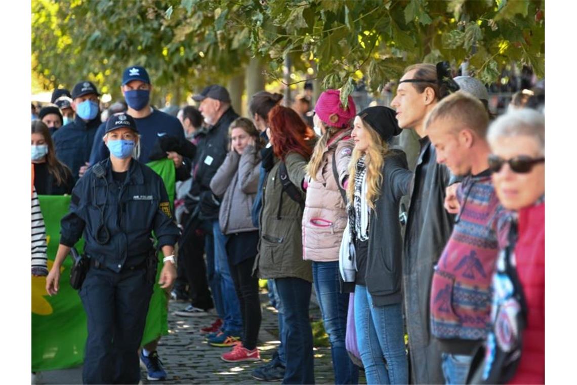 Menschen bilden eine sogenannte Friedensmenschenkette, die durch Deutschland, Österreich, Liechtenstein und die Schweiz rund um den Bodensee führen soll. Foto: Felix Kästle/dpa