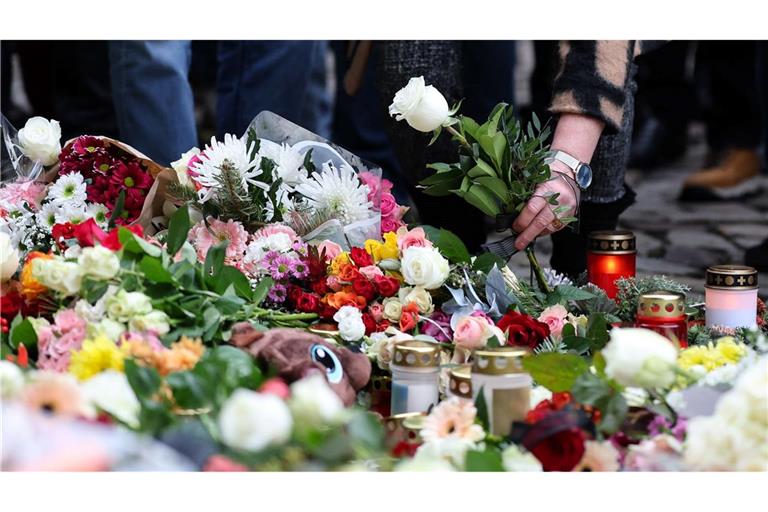 Menschen gedenken der Toten und Verletzten nach der Todesfahrt in Magdeburg.