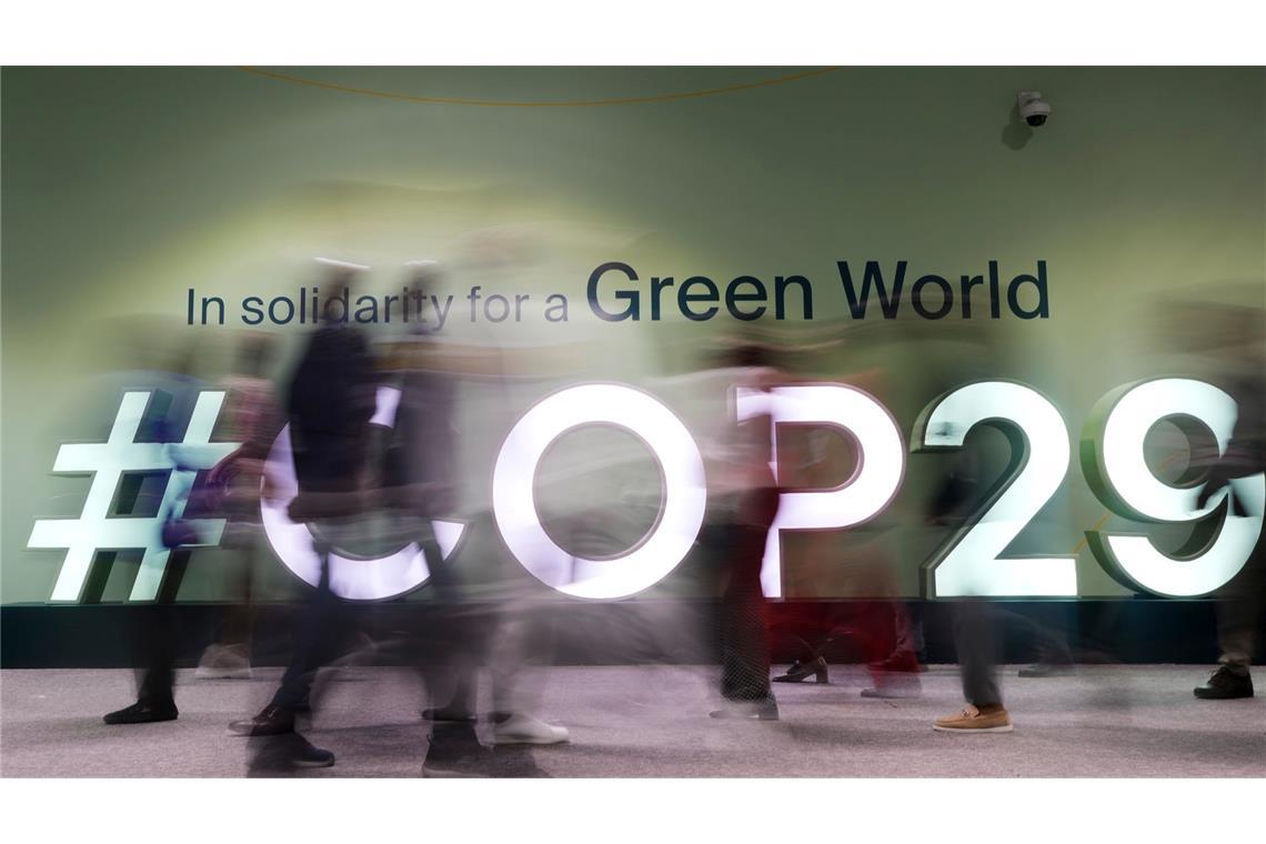 Menschen gehen durch das Konferenzgebäude in dem der UN-Klimagipfel COP29 statt findet.