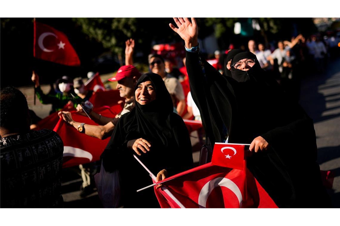 Menschen halten türkische Flaggen hoch, während sie sich zu Ehren der Opfer des gescheiterten Putschversuchs vom 15. Juli 2016 versammelten. (Archivbild)