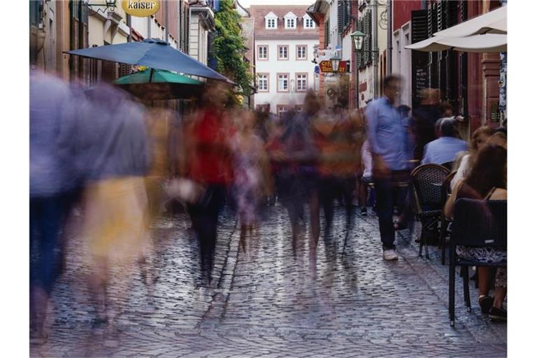 Menschen laufen am Abend in der Innenstadt durch die Untere Straße. Foto: Uwe Anspach/dpa/Archivbild