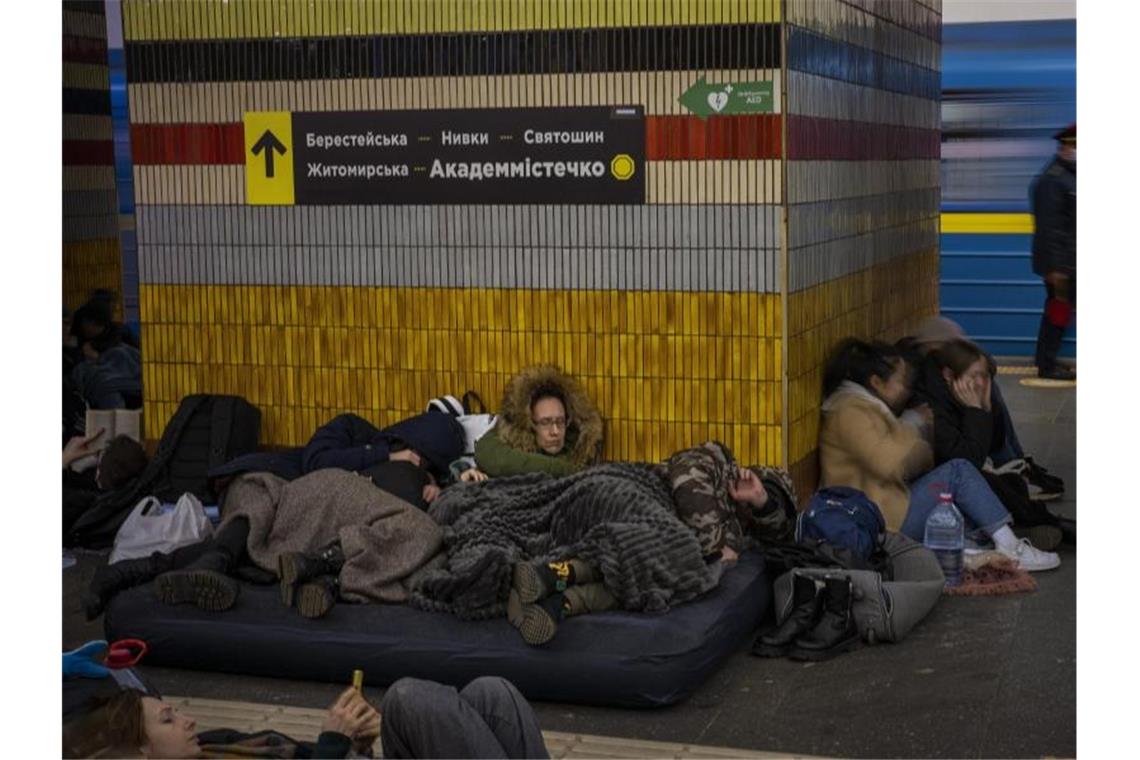 Menschen schlafen in einer U-Bahn-Station in Kiew, die als Luftschutzbunker genutzt wird. Foto: Emilio Morenatti/AP/dpa