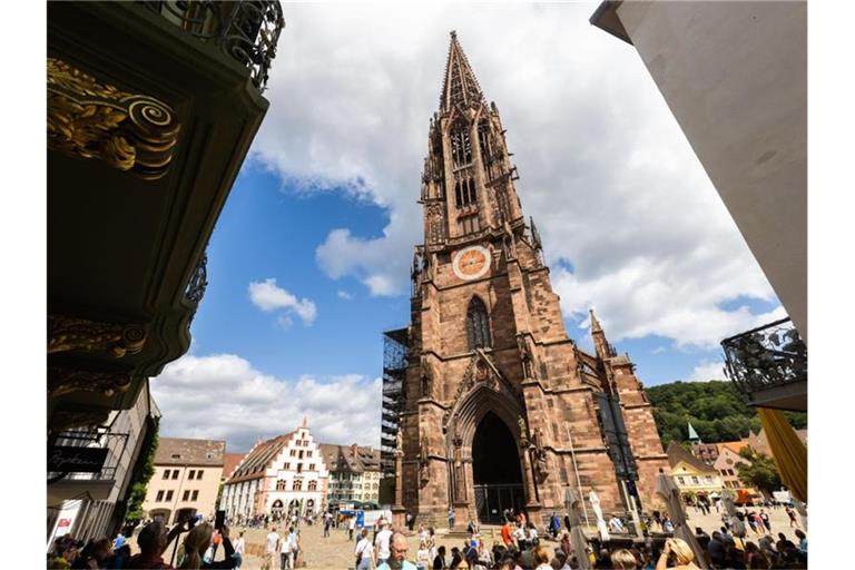 Menschen stehen auf dem Freiburger Münsterplatz vor dem Münster. Foto: Philipp von Ditfurth/dpa