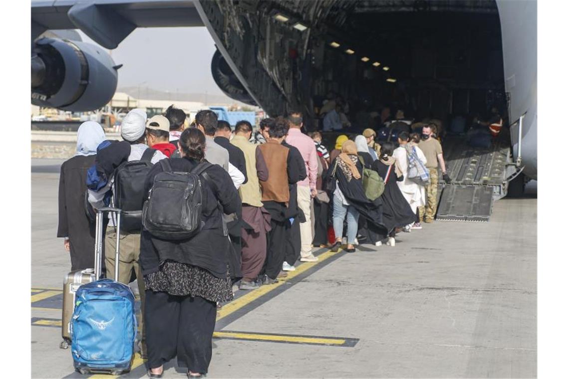 100 Millionen Euro für Flüchtlinge - Hubschrauber nach Kabul Menschen stehen auf dem Rollfeld und gehen an Bord eines US-Transportflugzeugs von Typ C-17 Globemaster III während ihrer Evakuierung am Hamid Karzai International Airport in Afghanistan. Foto: U.S. Marines/ZUMA Press Wire Service/dpa