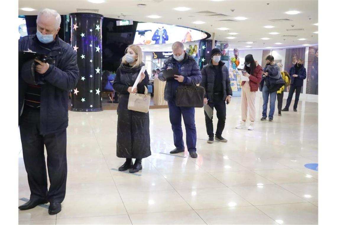Putin erinnert an Zehntausende Corona-Tote in Russland Menschen stehen in einem Einkaufszentrum in Moskau für eine Corona-Impfung an. (Symbolbild). Foto: Alexander Zemlianichenko Jr//XinHua/dpa