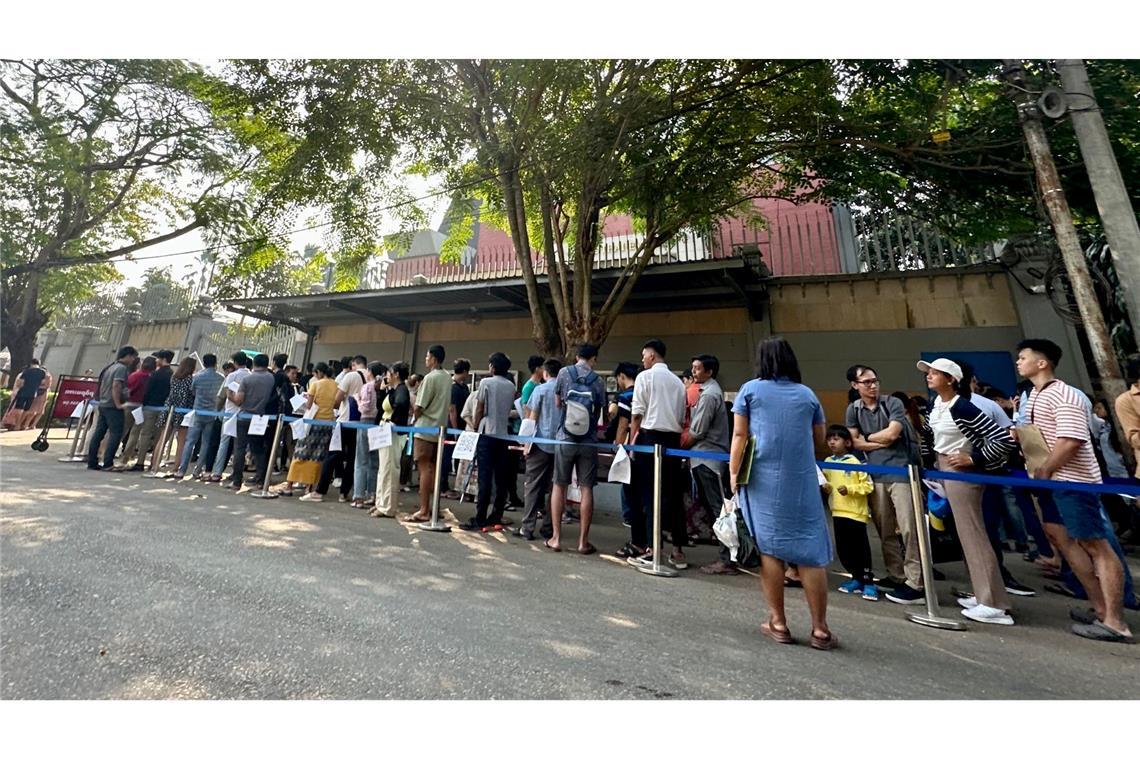 Menschen stehen vor der thailändischen Botschaft in Yangon in einer Schlange, um ein Visum zu erhalten.