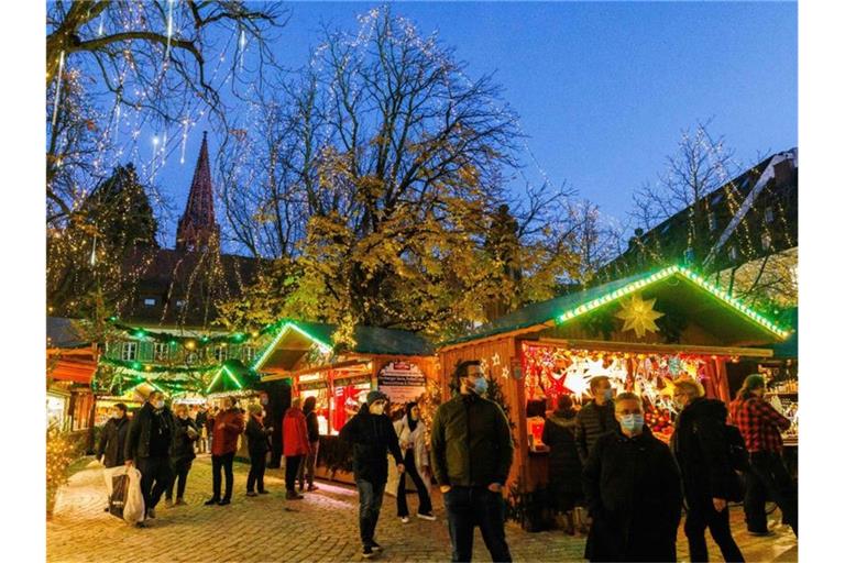 Menschen stehen vor Verkaufsständen auf dem Freiburger Weihnachtsmarkt. Foto: Philipp von Ditfurth/dpa/Bildarchiv