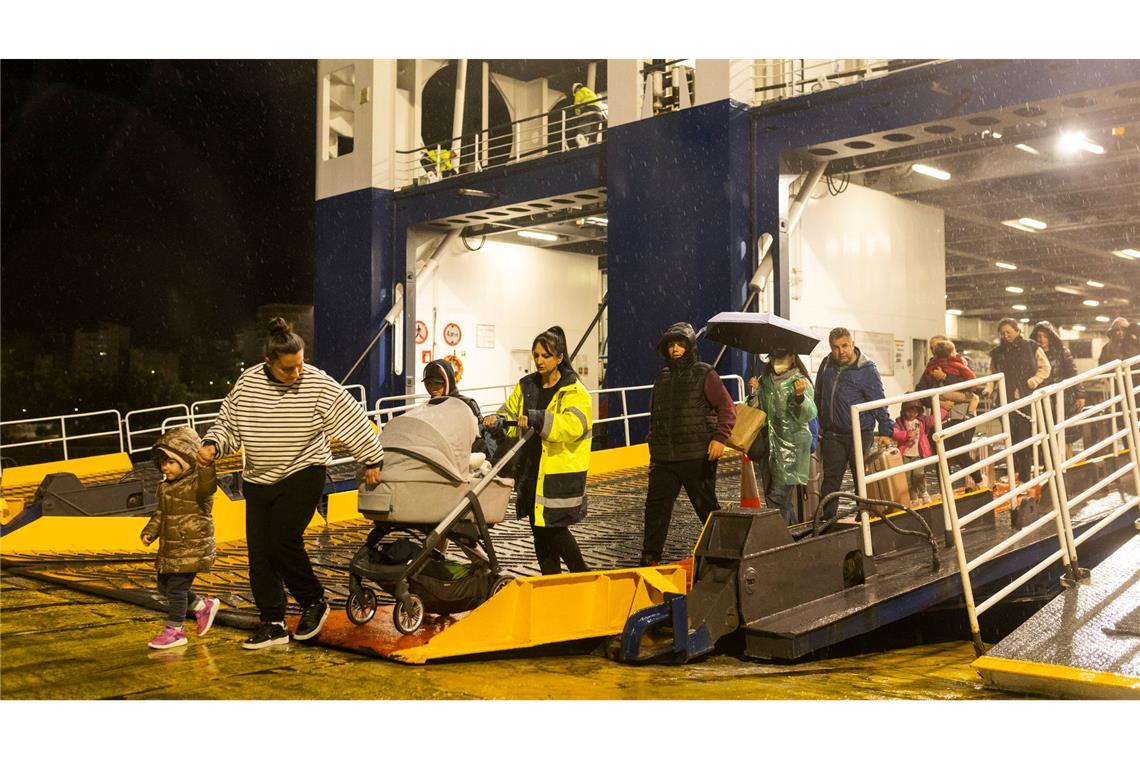 Menschen steigen im Hafen von Piräus von einer Fähre, mit der sie Santorini verlassen haben.