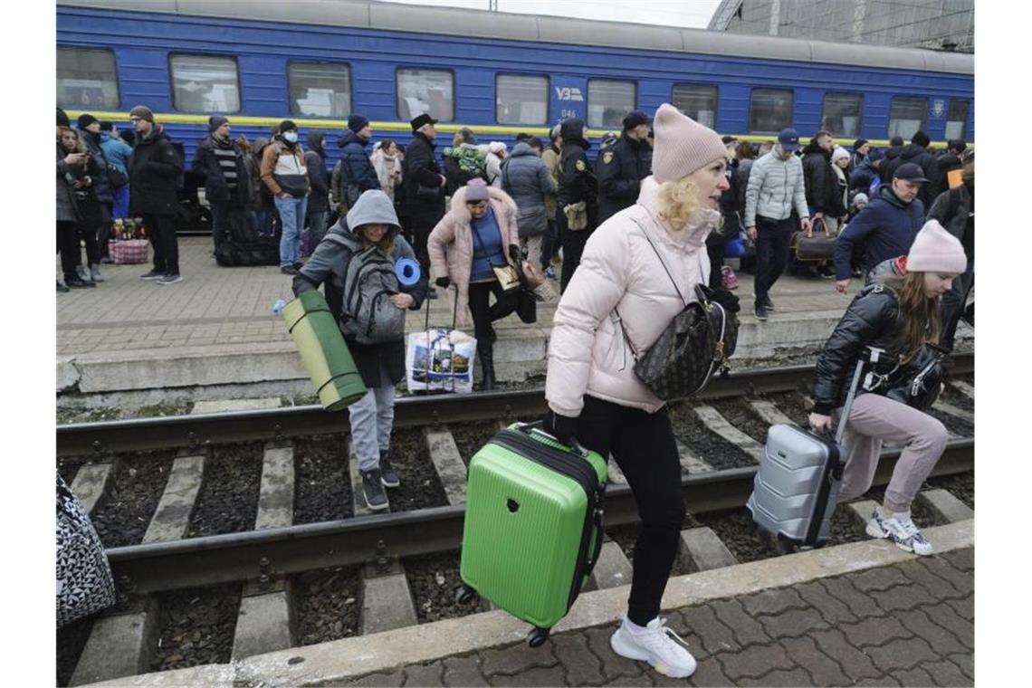 Menschen versammeln sich am Bahnhof in Lwiw im Westen der Ukraine, um einen Zug zu nehmen und die Ukraine in die Nachbarländer zu verlassen. Russische Truppen haben den erwarteten Angriff auf die Ukraine gestartet und drangen in die Hauptstadt vor. Foto: Mykola Tys/AP/dpa