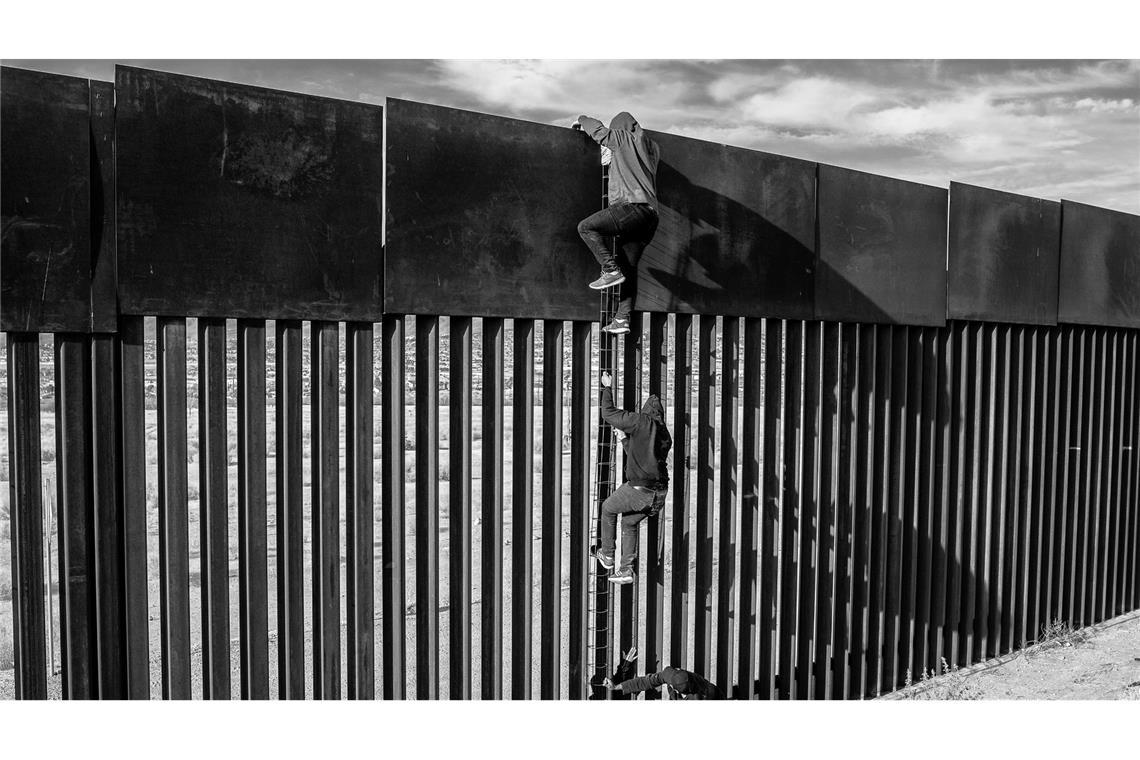 Migranten benutzen eine selbstgebaute Leiter, um mit Hilfe eines Schmugglers einen Teil der Grenzmauer zur USA zu erklimmen. Der aus Venezuela stammende Fotograf Alejandro Cegara wurde in der Kategorie langfristige Projekte für eine Serie über Immigration in Mexiko ausgezeichnet.