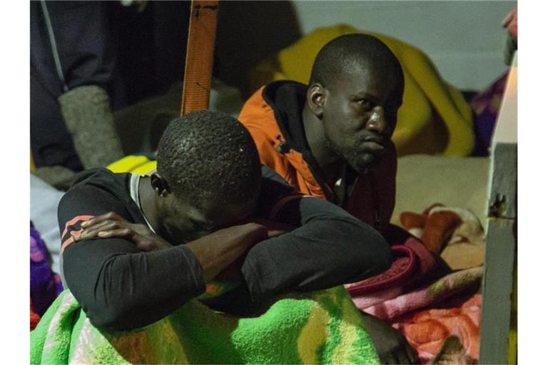 Migranten sitzen an Deck des unter deutscher Flagge fahrenden Schiffes „Alan Kurdi“. Foto: Karsten Jaeger/Sea-Eye/AP/dpa