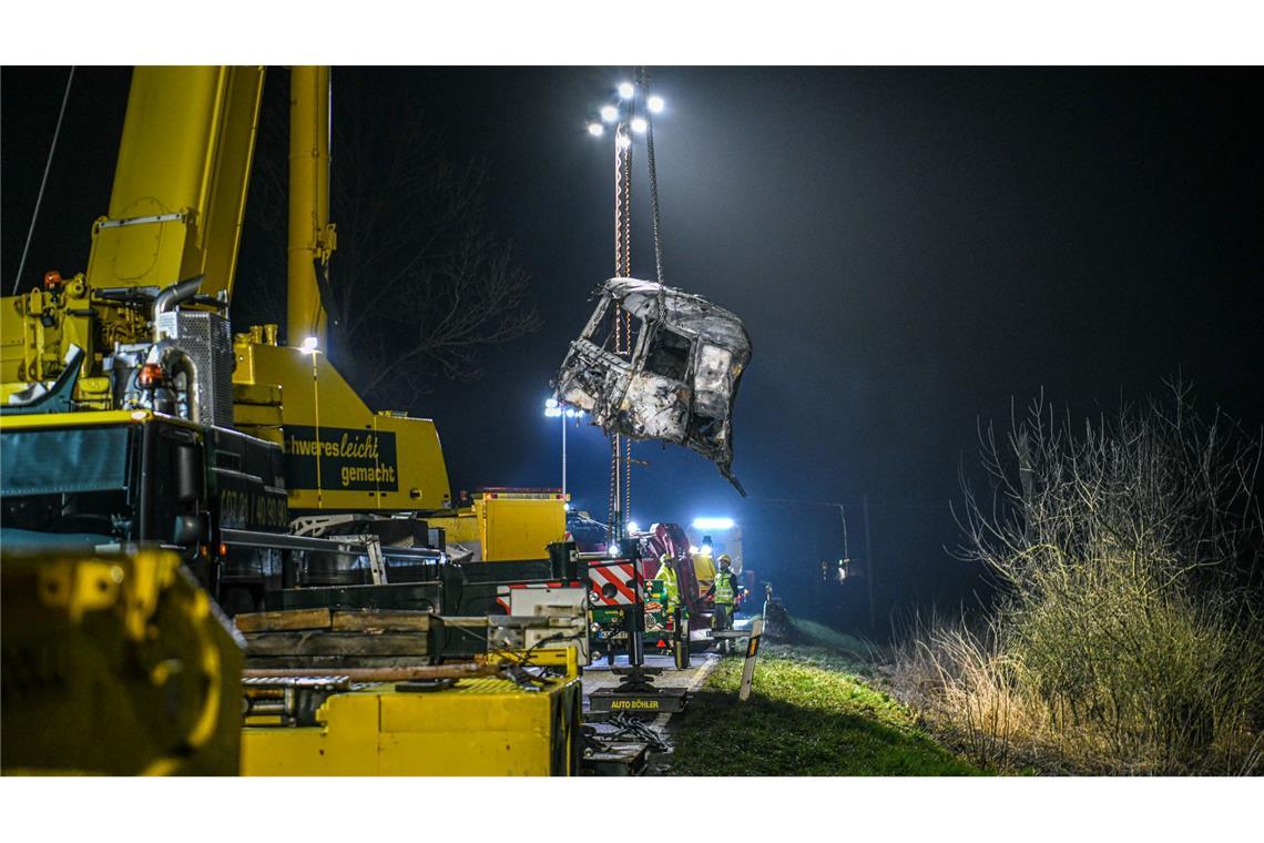 Mit einem großen Kran und unter Flutlicht werden Trümmerteile geborgen.