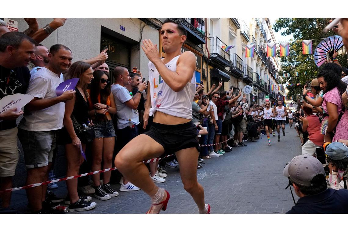 Mit großen Schritten rennt ein Teilnehmer des jährlichen High-Heels-Rennens während der Pride Week durch das Chueca-Viertel in Madrid.