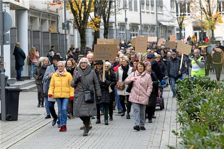 Mit Schildern und Trillerpfeifen ausgerüstet ziehen die Demonstrierenden durch die Grabenstraße. Die Vorsitzende der Seniorenvertretung, Dorothee Winter (dunkelgrauer Mantel und Brille, vorne) führt den Protestzug an. Foto: Alexander Becher