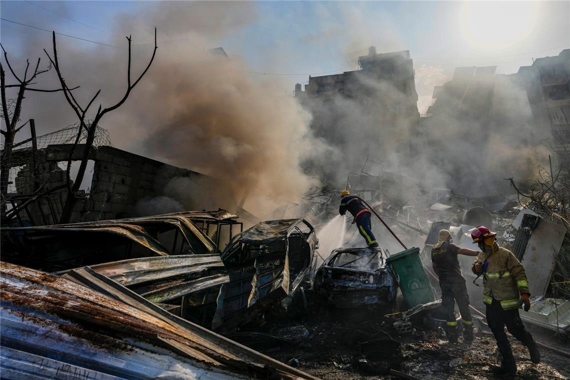 Mitarbeiter des Zivilschutzes löschen am 1.November ein Feuer, während Rauch vom Ort eines israelischen Luftangriffs in Dahiyeh aufsteigt.