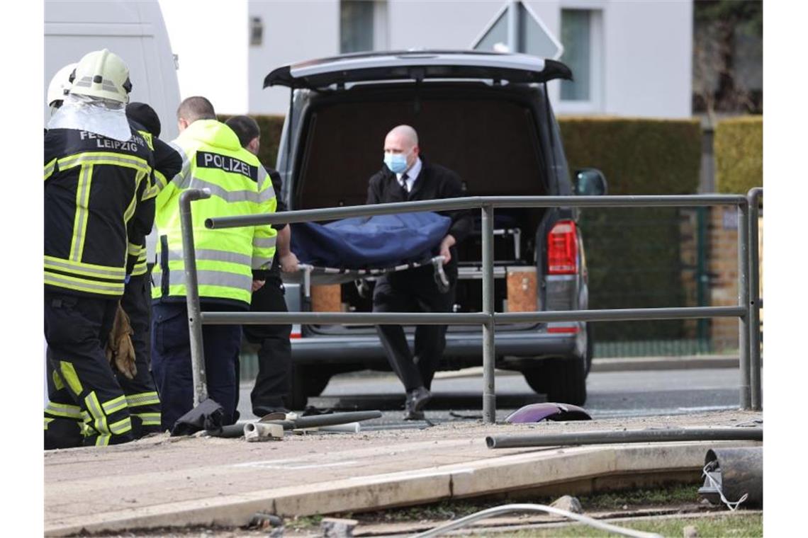 Auto fährt in Leipzig in Menschengruppe - drei Tote Mitarbeiter eines Bestattungsunternehmens tragen ein Opfer zu einem Leichenwagen. Foto: Jan Woitas/dpa-Zentralbild/dpa