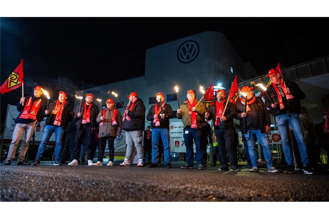 Mitarbeiter von Volkswagen stehen mit Fackeln vor dem VW Werk in Osnabrück. Die IG Metall hat ihre Mitglieder in der Metall- und Elektroindustrie zu flächendeckenden Warnstreiks aufgerufen.