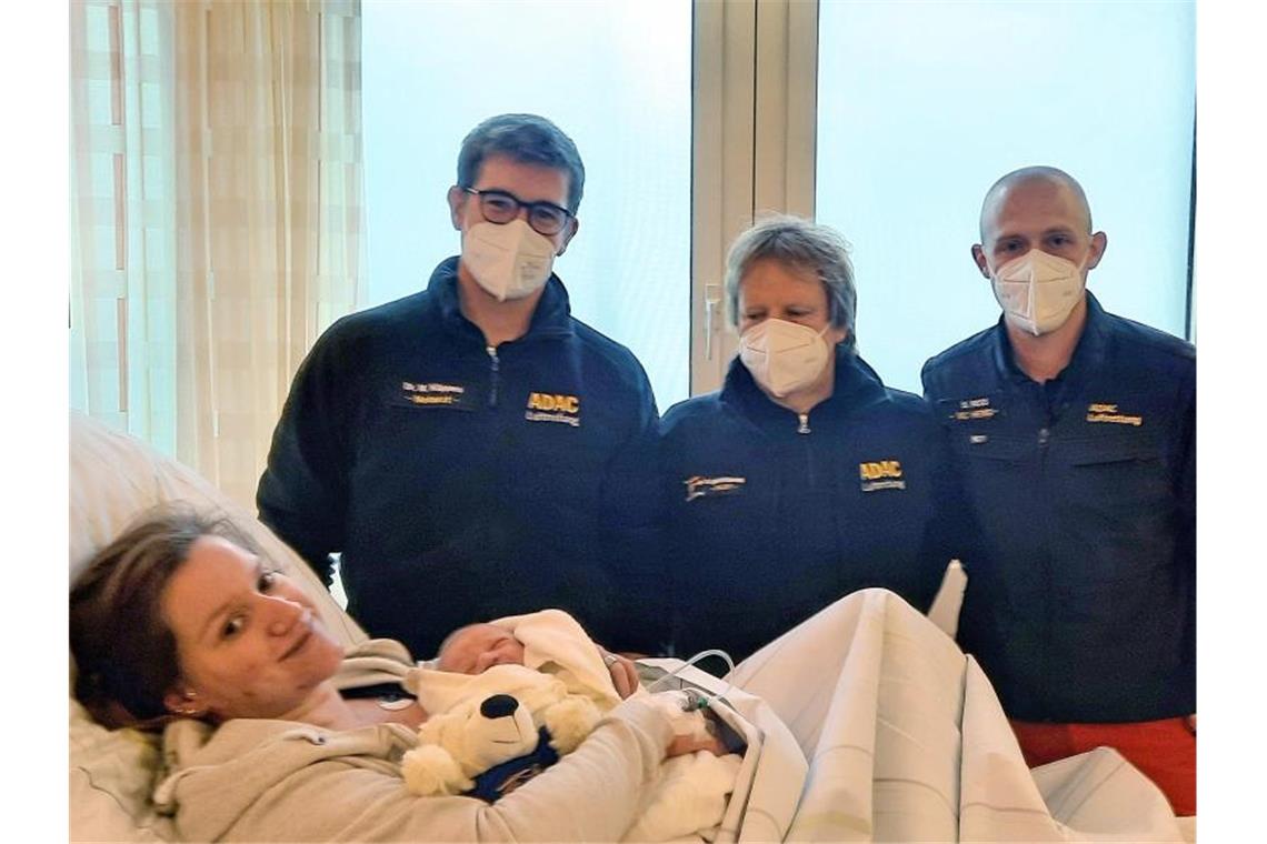 Baby Martin wurde im Rettungshubschrauber geboren Mutter Sonja Lammers liegt mit Baby Martin Timotheus auf der Geburtsstation der Klinik Osnabrück. Dahinter stehen die "fliegenden Geburtshelfer" vom ADAC. Foto: ADAC Luftrettung/dpa