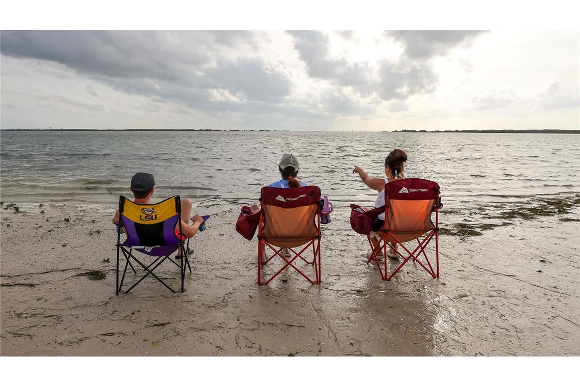 Nach dem das Hochwasser infolge des Hurrikans Helene sitzen Menschen am Dunedin Causeway in Florida