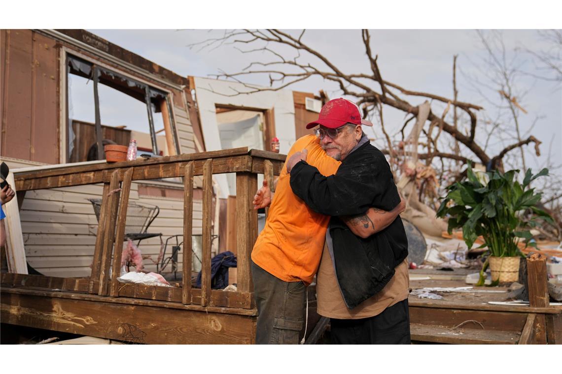 Nach dem Durchzug eines Tornados in Missouri spenden sich Nachbarn Trost und räumen auf.