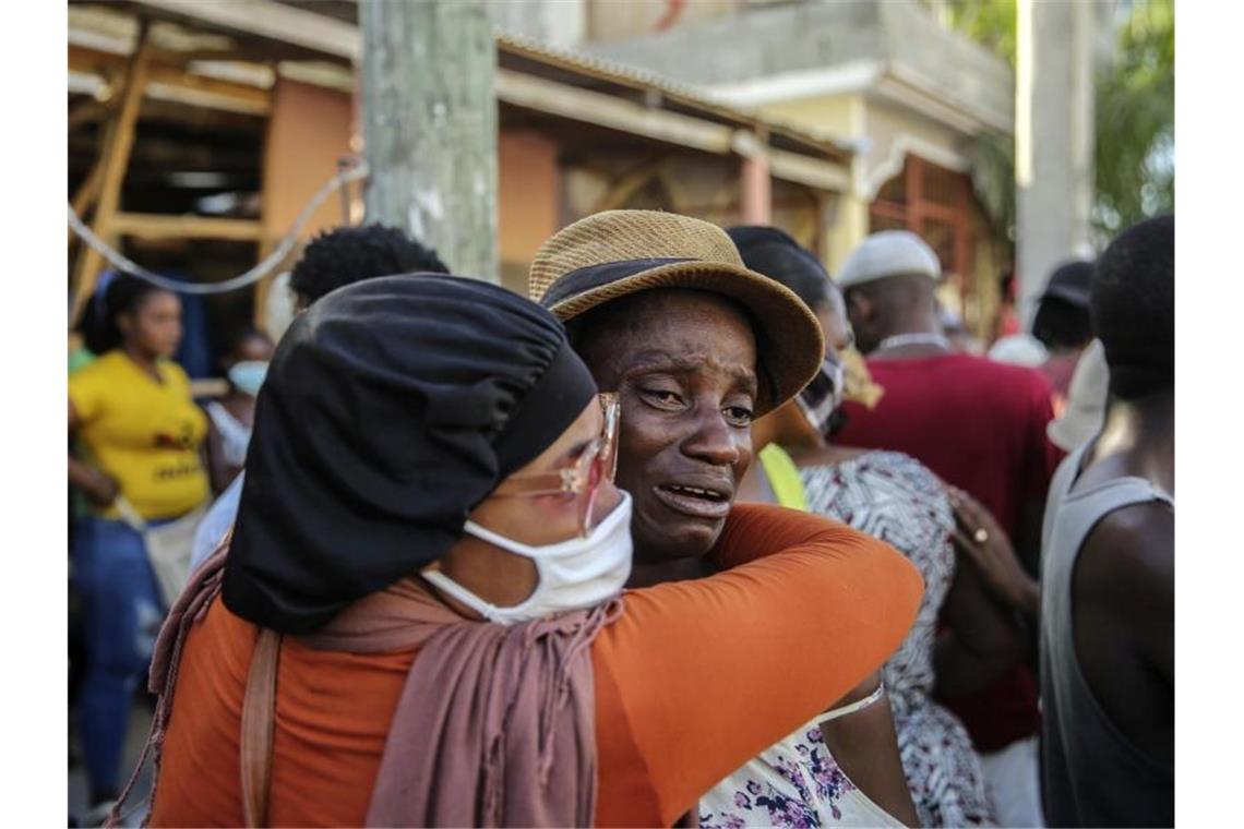 Erdbeben in Haiti: Fast 1300 Tote - Sturm nähert sich Nach dem Erdbeben der Stärke 7,2 in Haiti weinen Angehörige während der Suche nach Vermissten. Die Zahl der Todesopfer ist inzwischen auf über 1200 gestiegen. Foto: Joseph Odelyn/AP/dpa