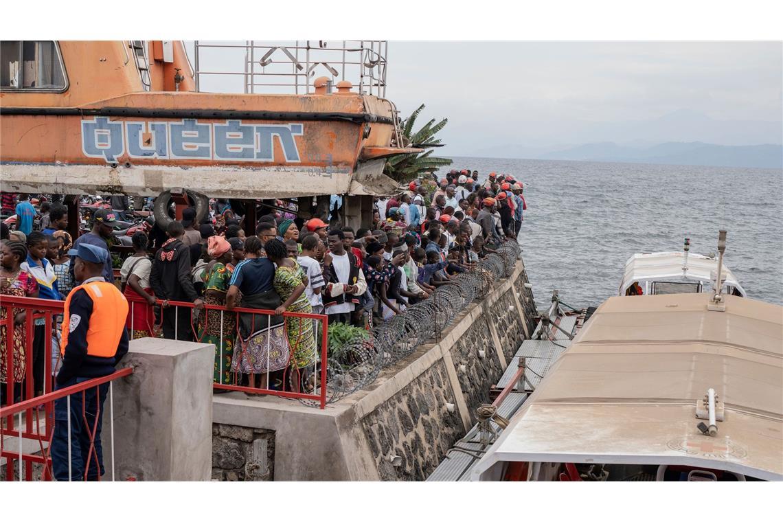 Nach dem Kentern einer Fähre versammeln sich Menschen am Hafen von Goma (aktuell)