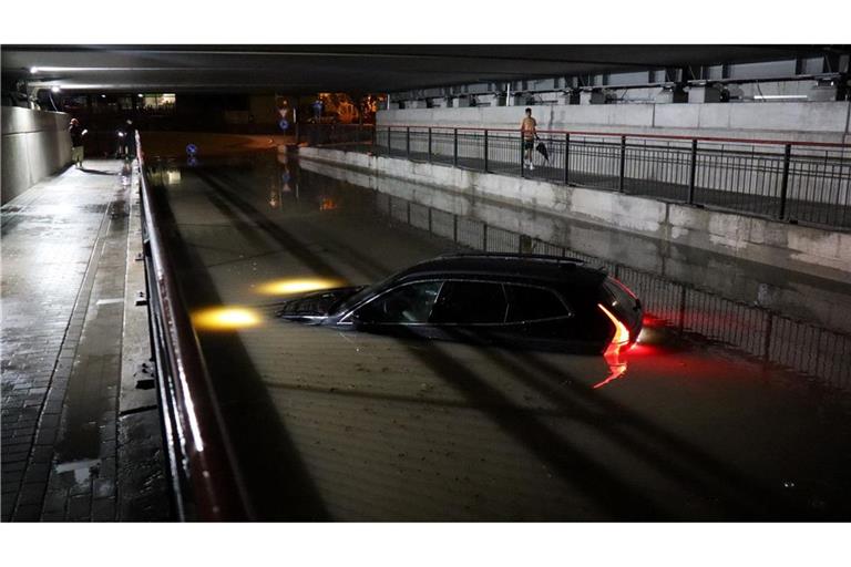 Nach einem schweren Gewitter steht ein Auto in Bruchsal bis zur Motorhaube im Wasser.