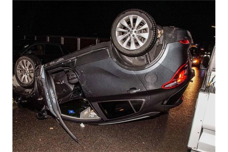 Nach einer Kollision mit einem geparkten Fahrzeug liegt ein Pkw auf dem Dach. Foto: Dettenmeyer/SDMG/dpa