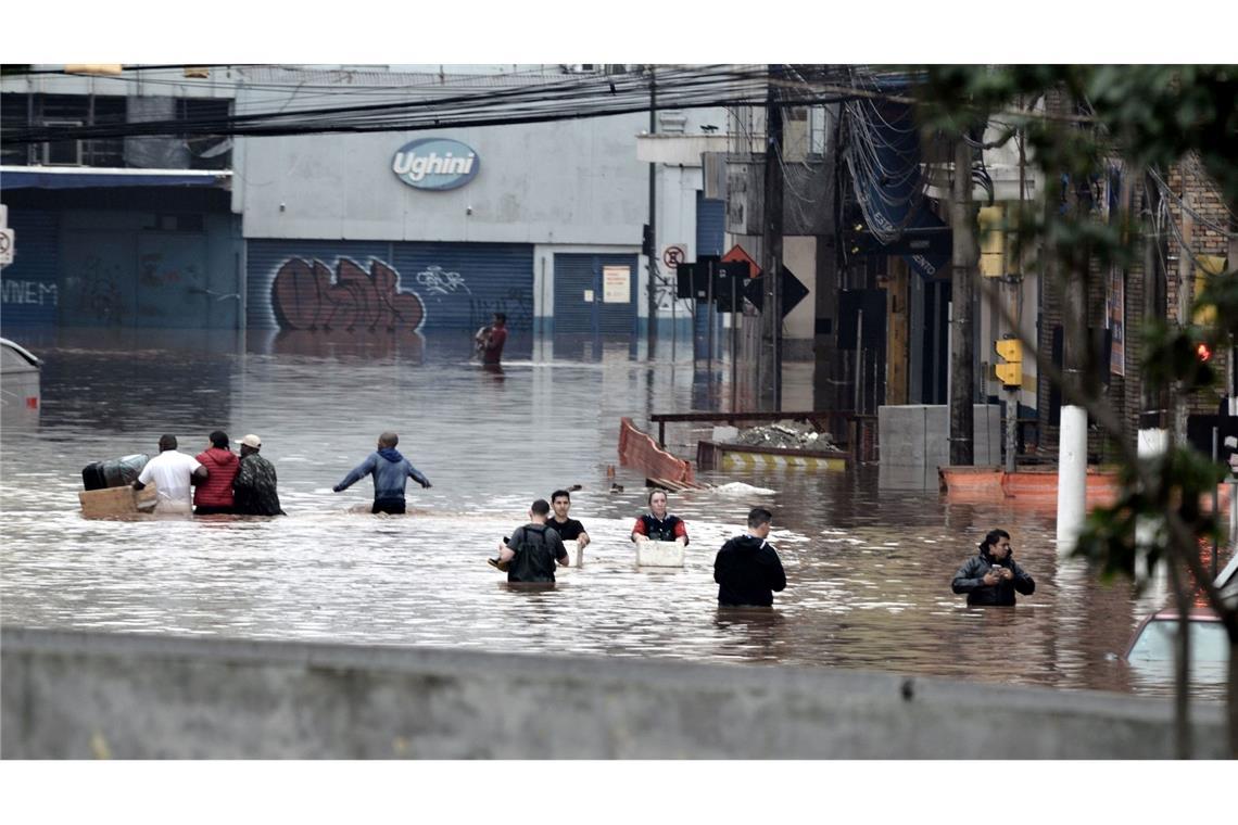 Nach schweren Regenfällen stehen in Porto Alegre, im Süden Brasiliens, die Straßen unter Wasser. Anwohnerinnen und Anwohner versuchen, ihre Habseligkeiten zu retten.