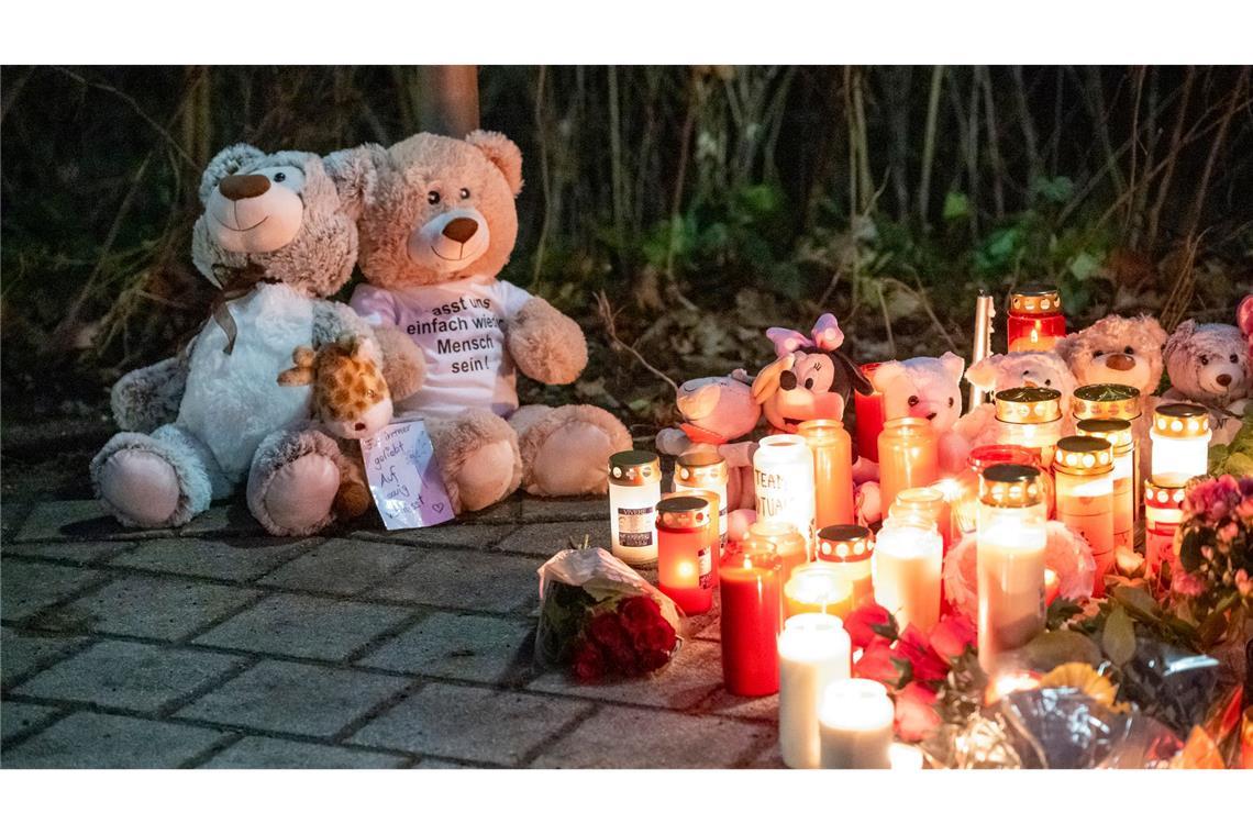 Nach tödlichem Angriff in einem Park in Aschaffenburg: Zwei Teddybären und zahlreiche Kerzen stehen im Park Schöntal.