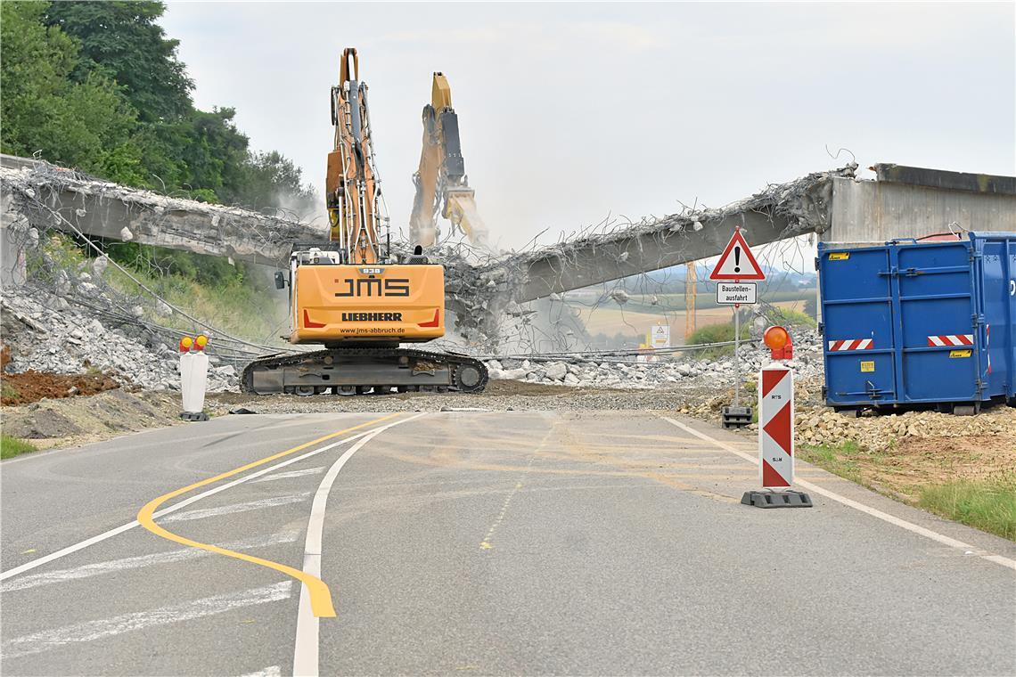 Nachdem sich zwei Bagger rund zwei Stunden an dem Überweg zum Schützenhaus abgearbeitet haben, fällt die Brücke über der B14 in sich zusammen. Fotos: Tobias Sellmaier