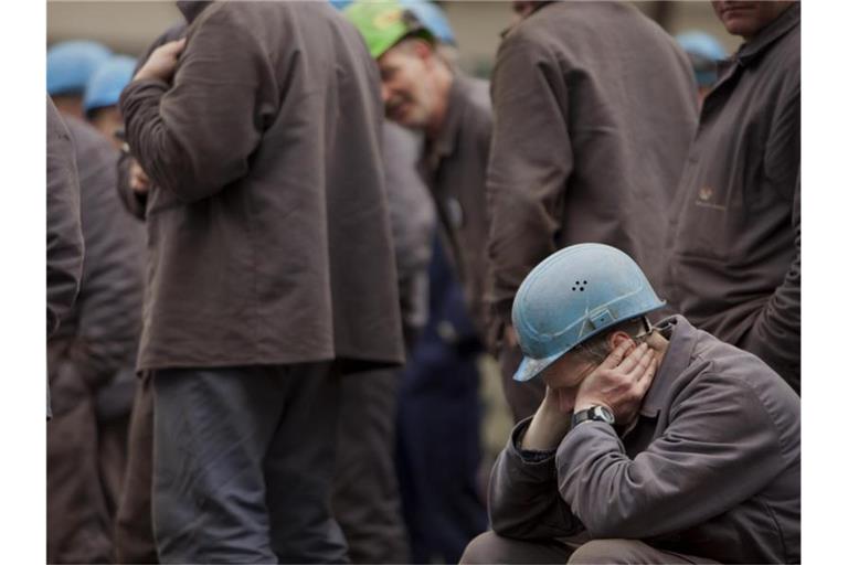 Nachdenklich: Arbeiter auf einem Werftgelände zwischen seinen Kollegen. Der Deutsche Industrie- und Handelskammertag sieht die Konjunktur auf Talfahrt. Foto: Arno Burgi/dpa-Zentralbild/dpa